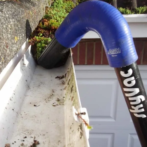 Gutters packed with moss and debris before professional clearing
